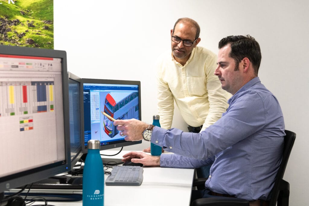 Two men working together in front of a computer